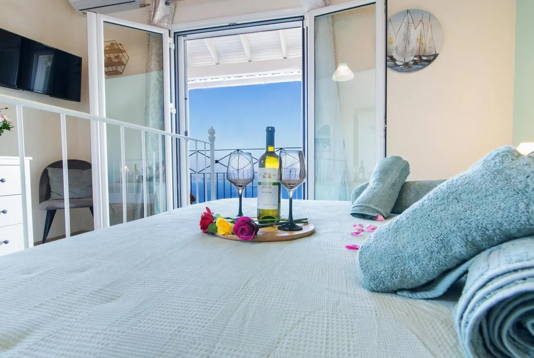 Wine on bed with balcony view
